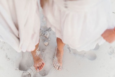 Low section of woman standing on snow