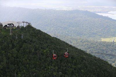 Overhead cable car over mountains against sky