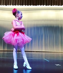 Full length of girl wearing tutu standing at ballet studio