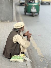 Rear view of man with umbrella on street