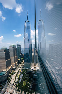 One world trade center in city against cloudy sky