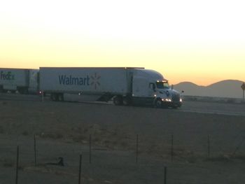 Side view of train against clear sky at sunset