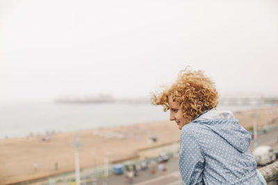 Woman at brighton pier looking at beach against clear sky