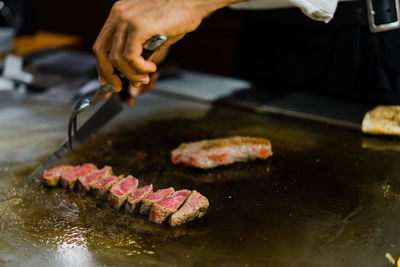 Cropped hand of man preparing food on table wagyu beef in japan