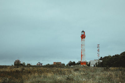 Water tower on field against sky