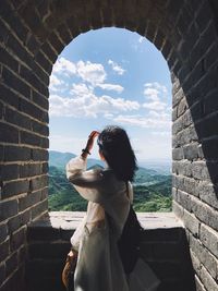 Rear view of woman standing against sky