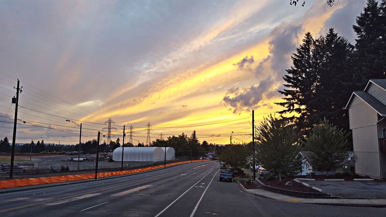 CARS ON ROAD AGAINST SKY AT SUNSET