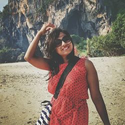 Portrait of smiling young woman standing on beach