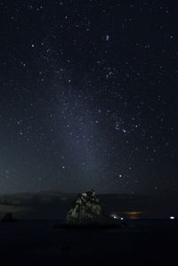 Scenic view of sea against star field at night