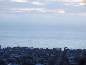 High angle view of townscape by sea against sky