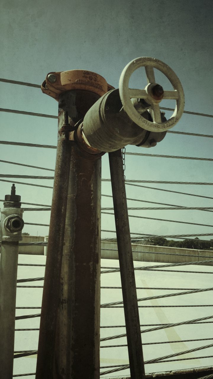 low angle view, electricity, built structure, metal, technology, lighting equipment, fuel and power generation, old-fashioned, architecture, clear sky, sky, day, no people, connection, old, power line, power supply, outdoors, safety, building exterior