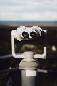 Close-up of coin-operated binoculars against sea