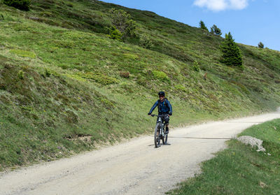 Rear view of man riding bicycle on mountain