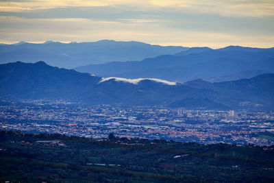 High angle view of illuminated cityscape against sky at sunset