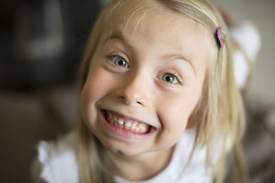 Portrait of cheerful cute girl making face at home