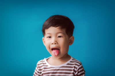 Portrait of boy against blue background