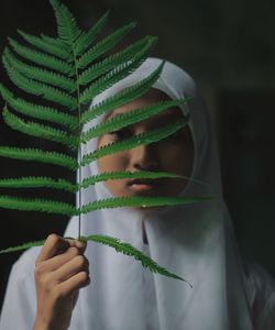 Close-up of woman holding plant