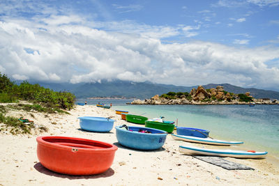 Deck chairs on beach against sky