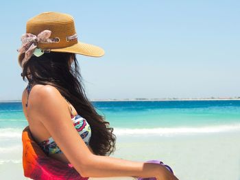 Close-up of woman standing at beach against clear sky