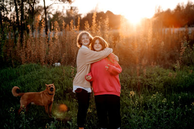 Rear view of woman standing with dog on field