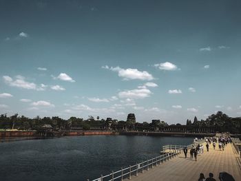 Scenic view of river by buildings against sky