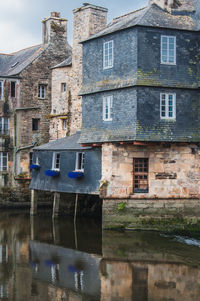 Canal by old building against sky