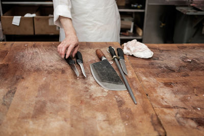 Midsection of butcher in shop