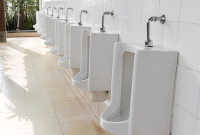 White urinals on tiled wall