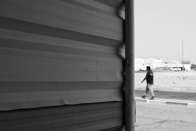 Side view of man walking against wall