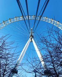 Low angle view of ferris wheel against clear blue sky