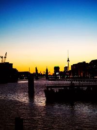 Silhouette of buildings in city during sunset