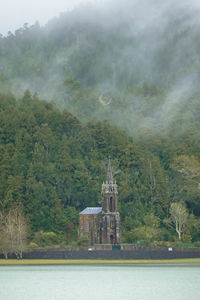 Scenic view of building by mountains against sky