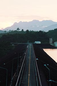 Railroad tracks by road against sky