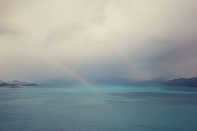 Scenic view of rainbow over sea against sky