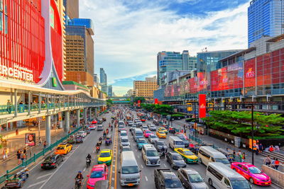 Traffic on city street amidst buildings against sky