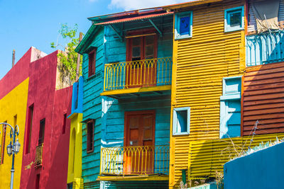 Low angle view of multi colored buildings against blue sky