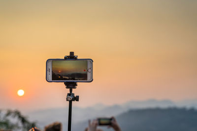 Telephone pole against sky during sunset