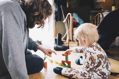 Father playing with girl while sitting at home