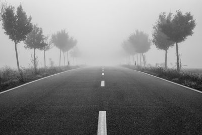 Low angle view from the middle of a road quickly disappearing into dense fog
