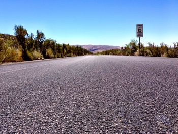 Surface level of road against clear blue sky