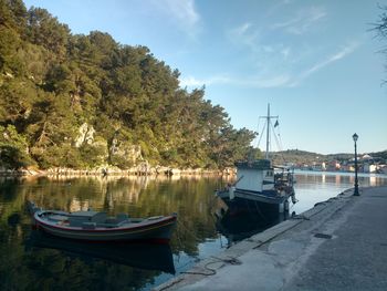 Boats moored by lake against sky