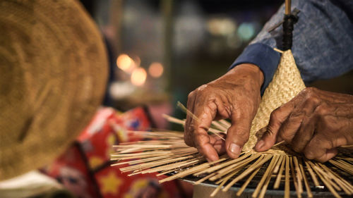 Close-up of hands weaving hat