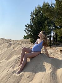 Low angle view of woman sitting on rock