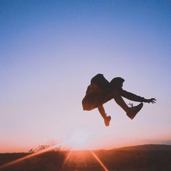 Silhouette man jumping against clear sky during sunset