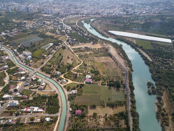 River and irrigation canal at the rural area with city at the horizon. aerial view