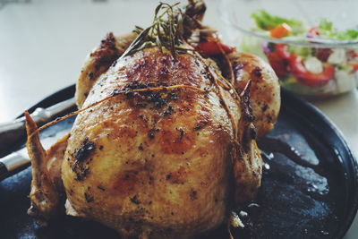 Close-up of roasted chicken in plate on table