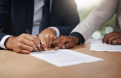 Midsection of business colleagues working on table