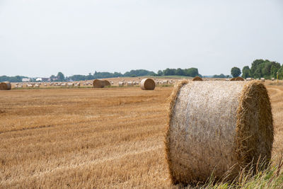 Hay bales on field against sky