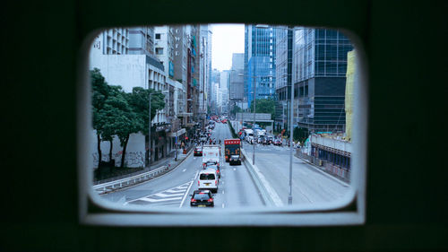 Vehicles on road in city seen through windshield