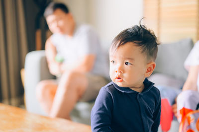 Cute boy looking away while sitting at home